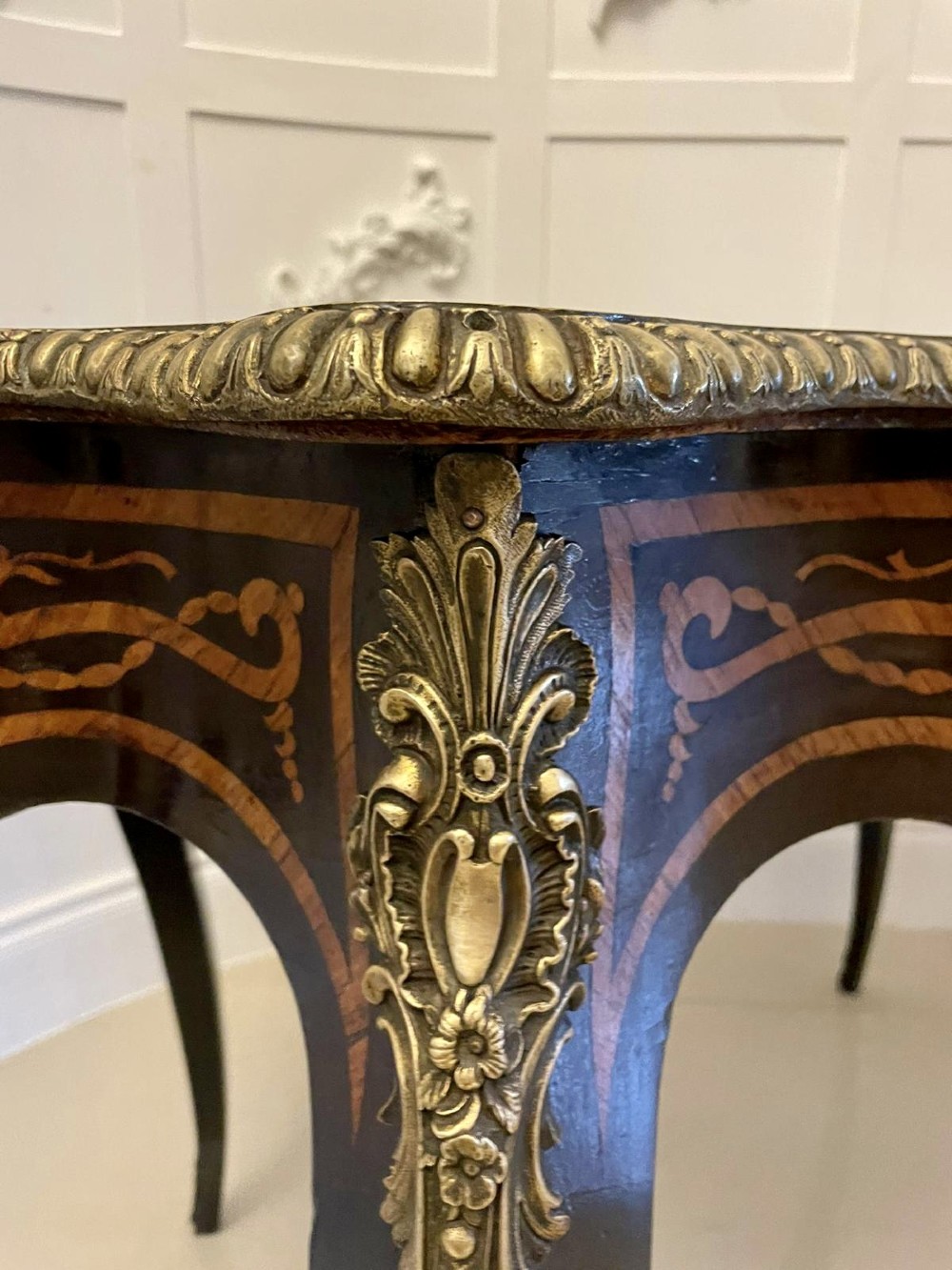 An antique French Rococo Revival centre table featuring detailed marquetry and parquetry wood patterns, serpentine edges, brass ormolu mounts, and curved cabriole legs. View XIII