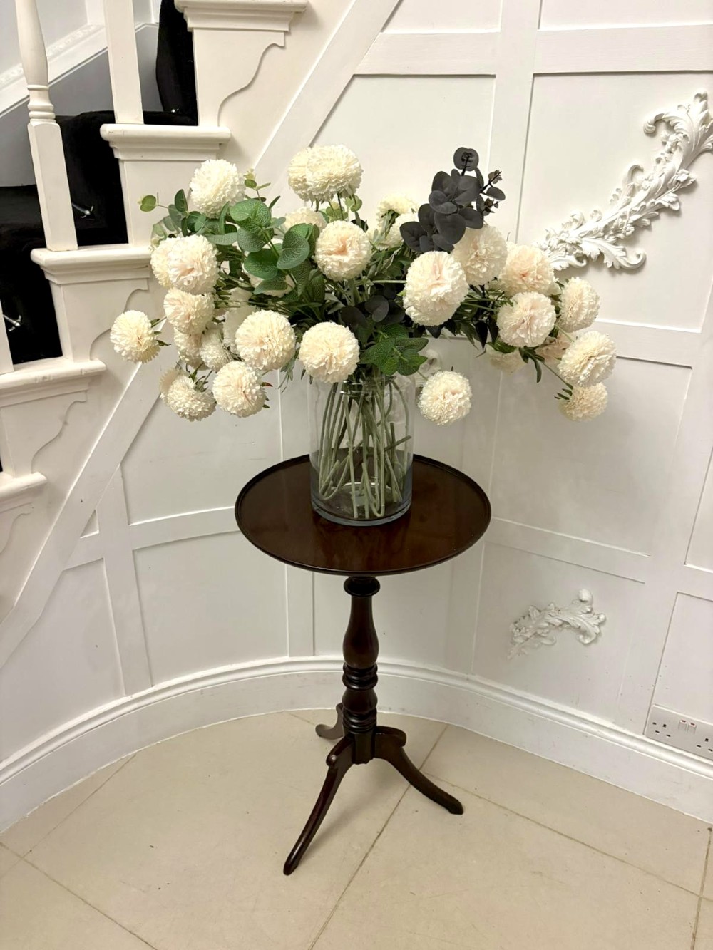 A circular dark mahogany tripod table featuring a moulded rim, turned baluster column, and three shaped legs. View III