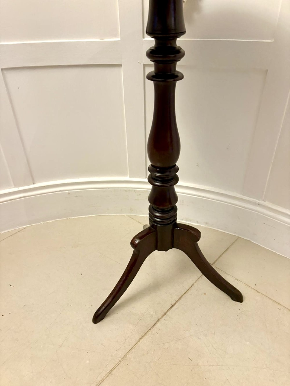A circular dark mahogany tripod table featuring a moulded rim, turned baluster column, and three shaped legs. View IV