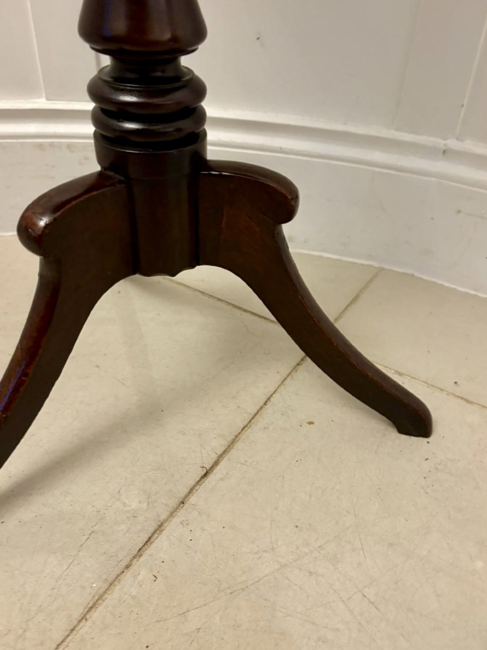 A circular dark mahogany tripod table featuring a moulded rim, turned baluster column, and three shaped legs. View VI