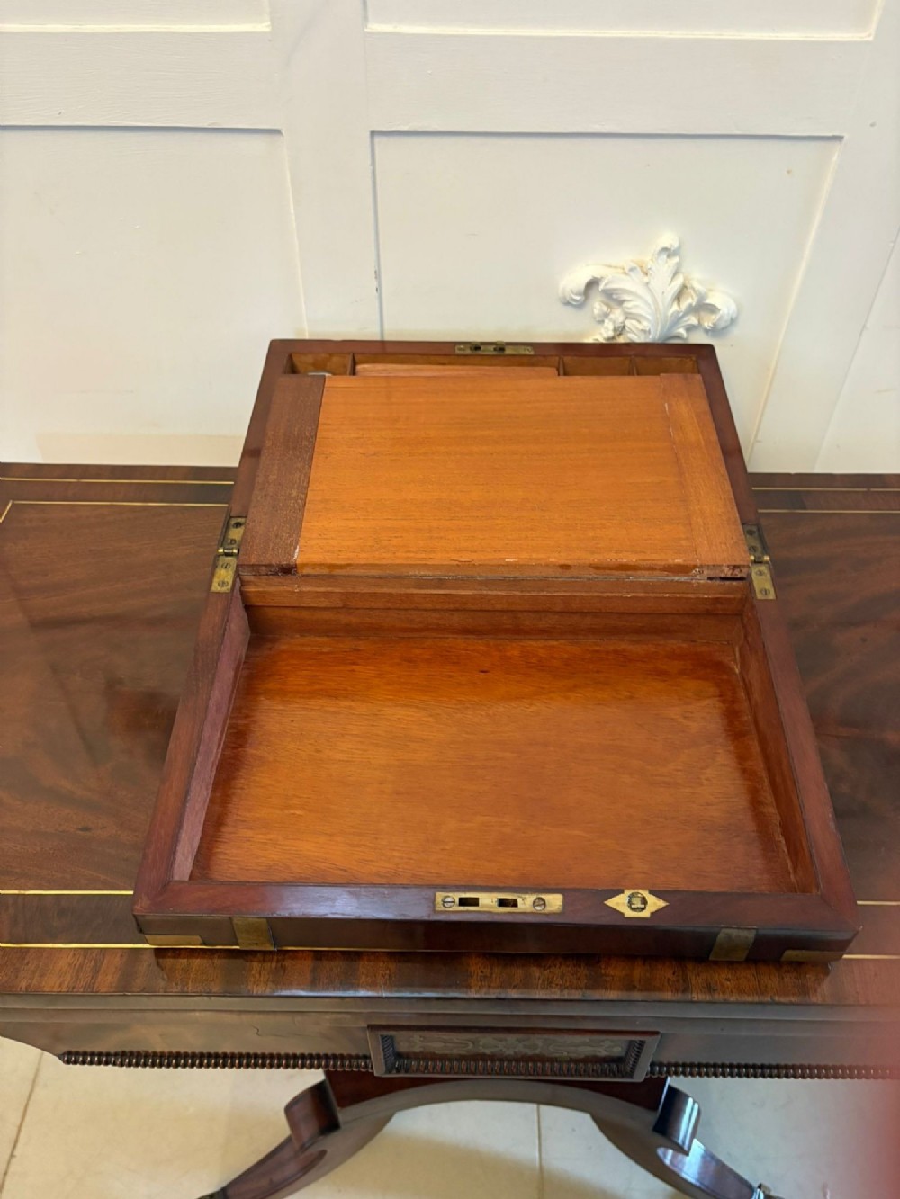 A rectangular Victorian mahogany writing box featuring brass corner brackets, vertical brass strapping, a central brass shield inlay, and a brass keyhole escutcheon. View IV