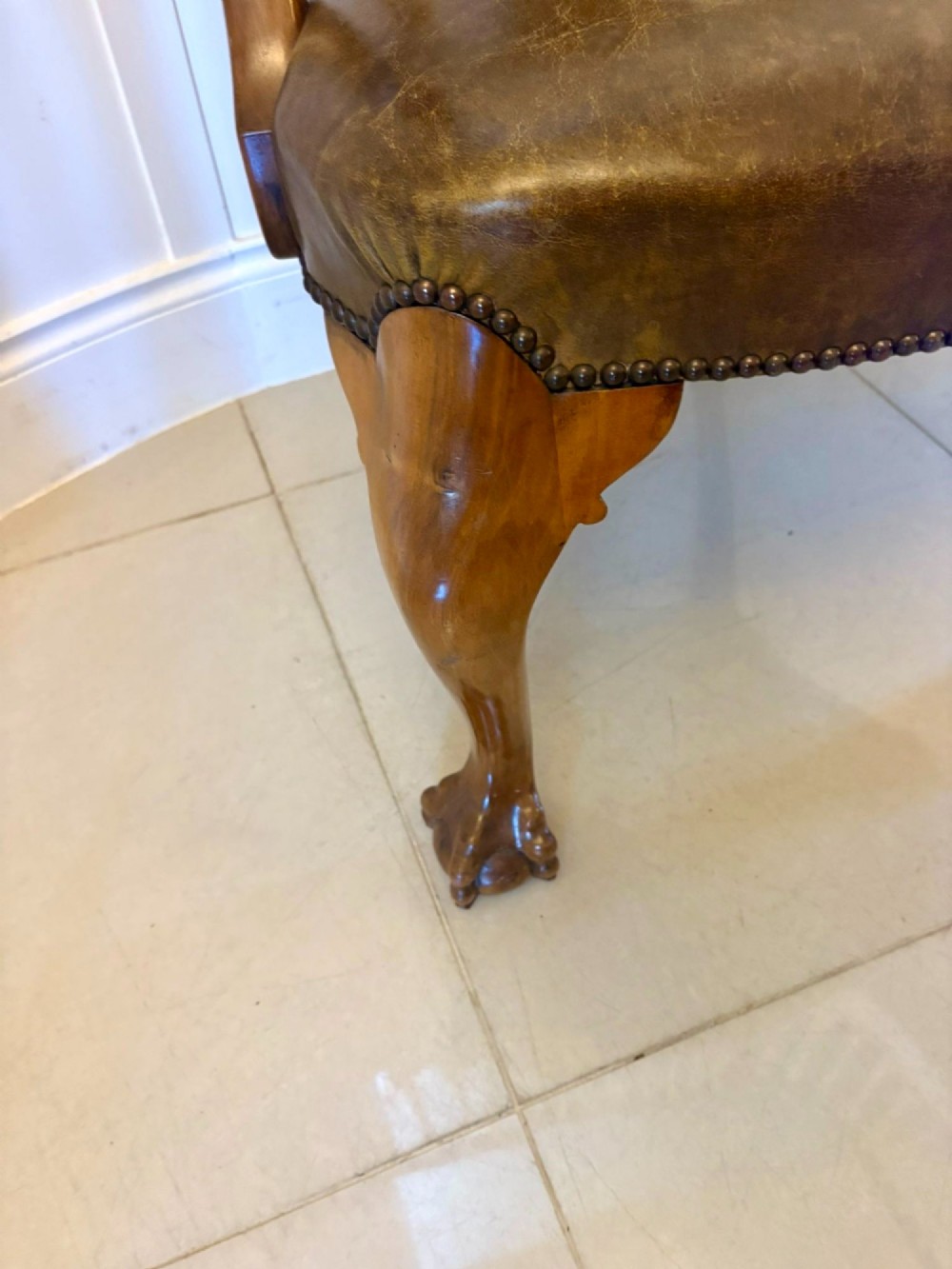 A pair of carved walnut desk armchairs featuring vasiform splats, green leather seats with brass studding, and cabriole legs ending in ball and claw feet. View VI