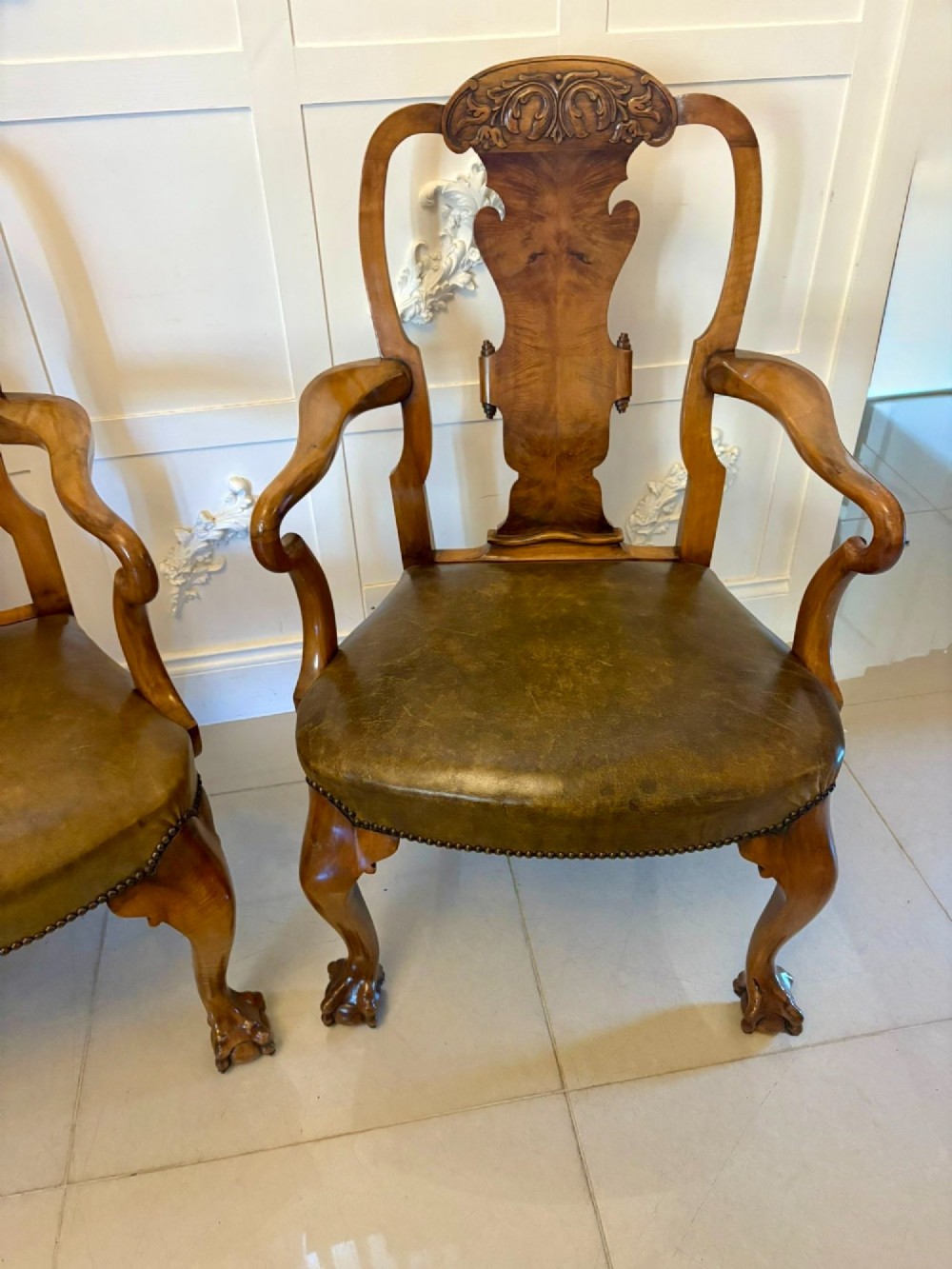 A pair of carved walnut desk armchairs featuring vasiform splats, green leather seats with brass studding, and cabriole legs ending in ball and claw feet. View XII
