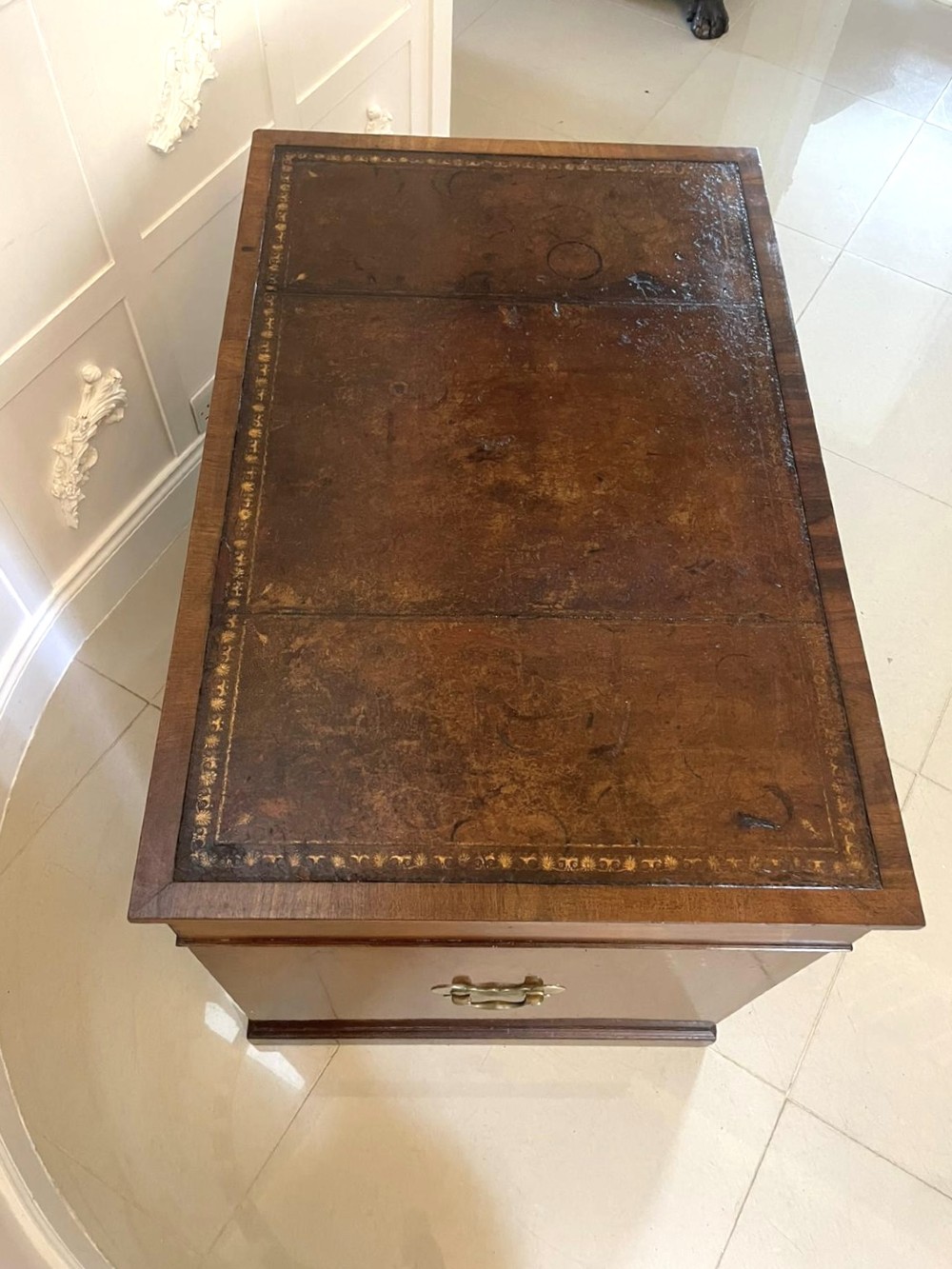 A Victorian mahogany freestanding kneehole desk featuring a leather writing insert, multiple drawers with brass handles, and side brass carrying handles. View XI