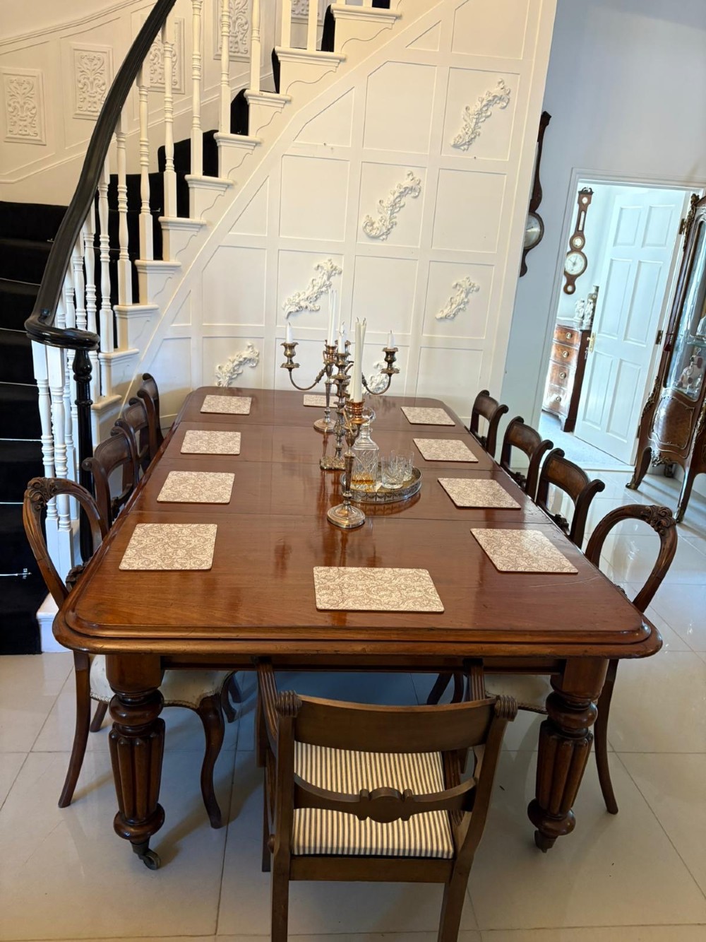 A large Victorian mahogany extending dining table with a polished surface, moulded rim, additional leaves, and turned fluted legs on brass castors. View IX