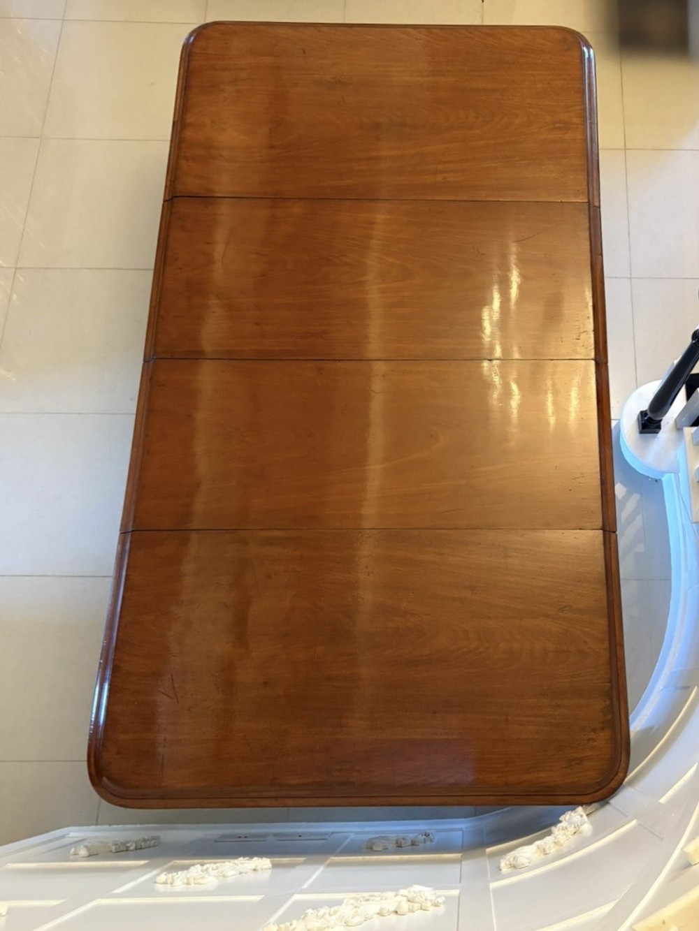 A large Victorian mahogany extending dining table with a polished surface, moulded rim, additional leaves, and turned fluted legs on brass castors. View X