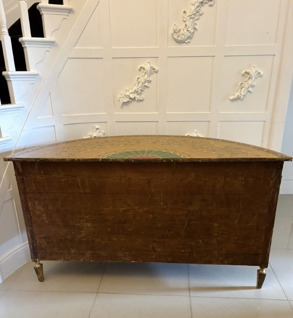 A semicircular satinwood demi-lune cabinet featuring hand-painted neoclassical leaf swags, a central figural medallion, and short tapered feet. View IV