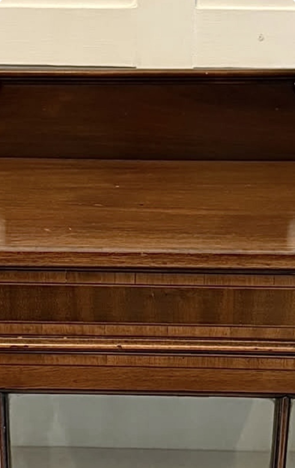 An Edwardian mahogany glazed display cabinet featuring geometric glazing bars, tapered legs, a raised pediment top, and a light-lined interior with three shelves. View III