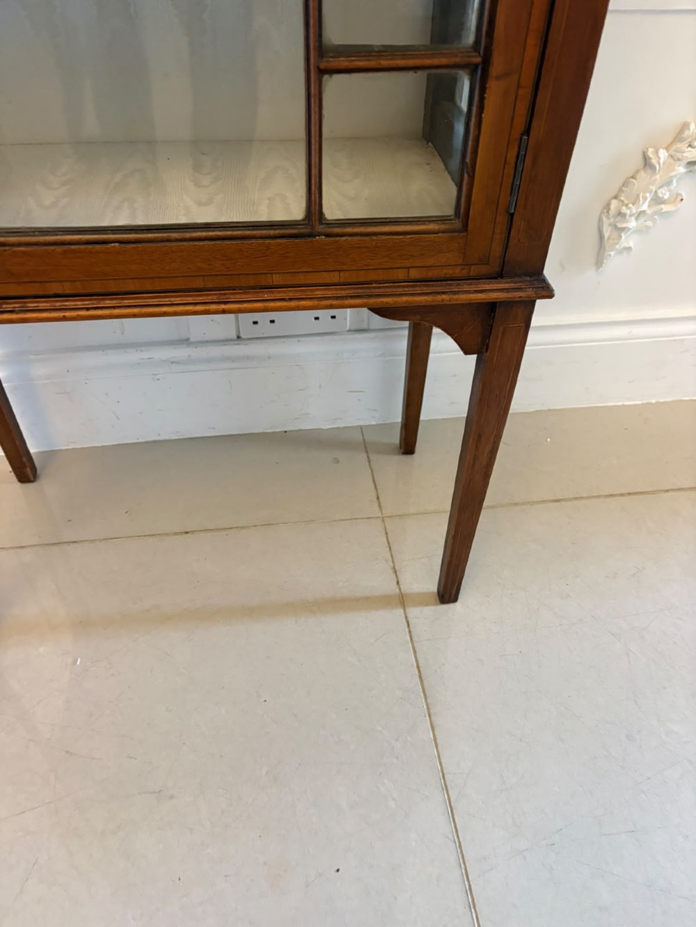 An Edwardian mahogany glazed display cabinet featuring geometric glazing bars, tapered legs, a raised pediment top, and a light-lined interior with three shelves. View XI