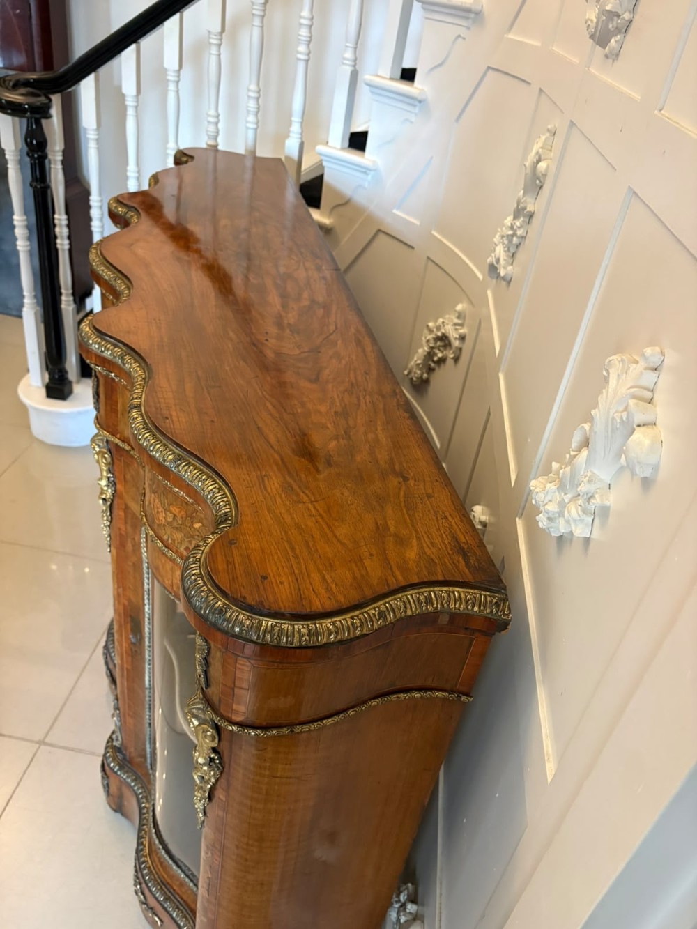 A Victorian serpentine burr walnut credenza featuring detailed floral marquetry inlays, gilt-bronze mounts, a central panelled door, and two curved glazed side doors. View IX