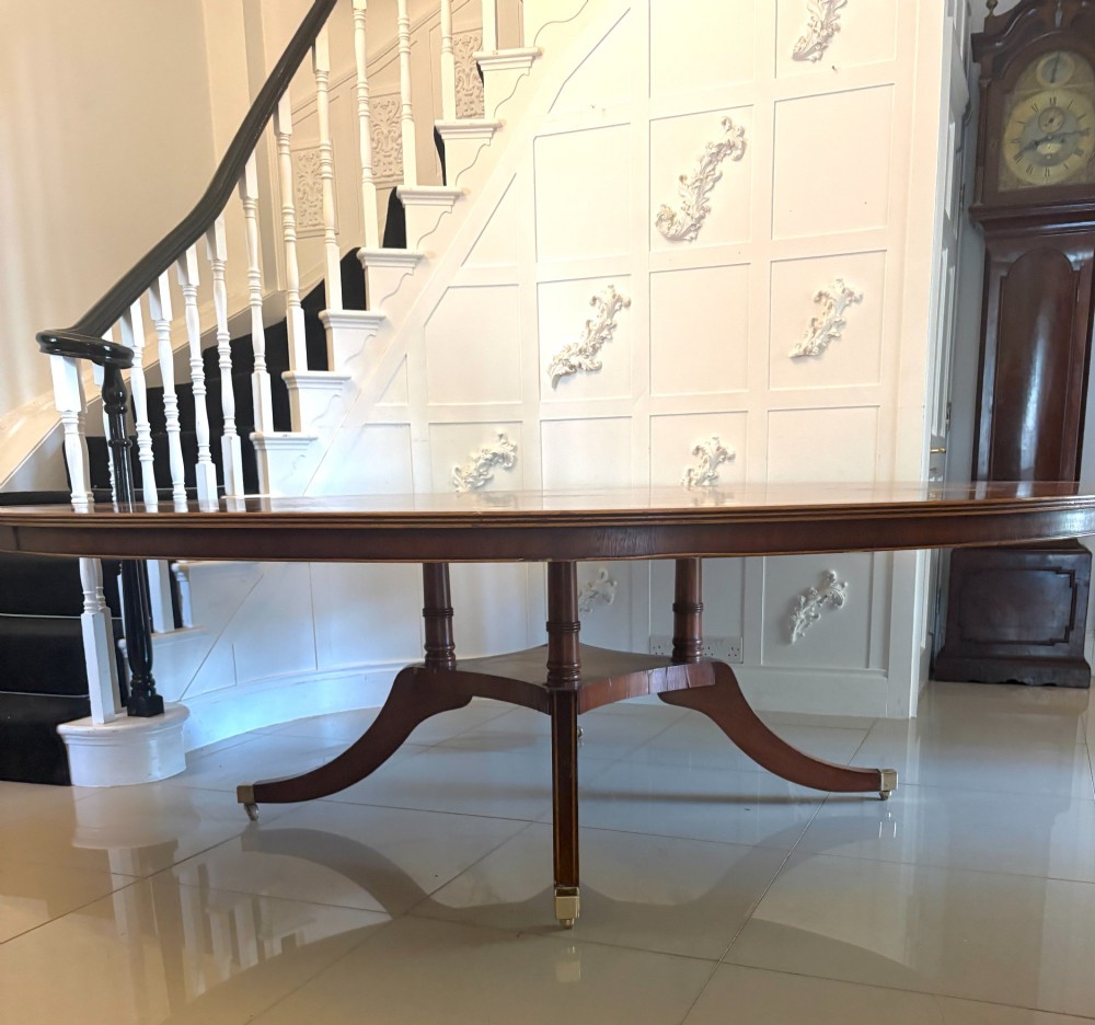 A large circular mahogany dining table featuring a yew wood crossbanded border and a central pedestal base. View III