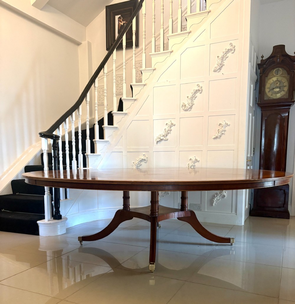 A large circular mahogany dining table featuring a yew wood crossbanded border and a central pedestal base. View IV