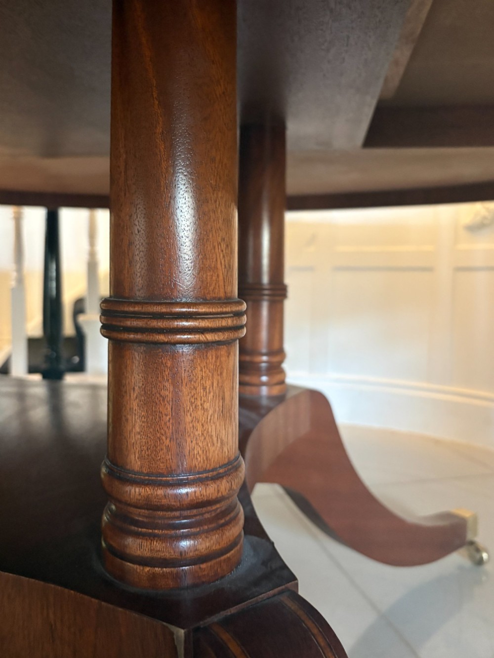A large circular mahogany dining table featuring a yew wood crossbanded border and a central pedestal base. View VII