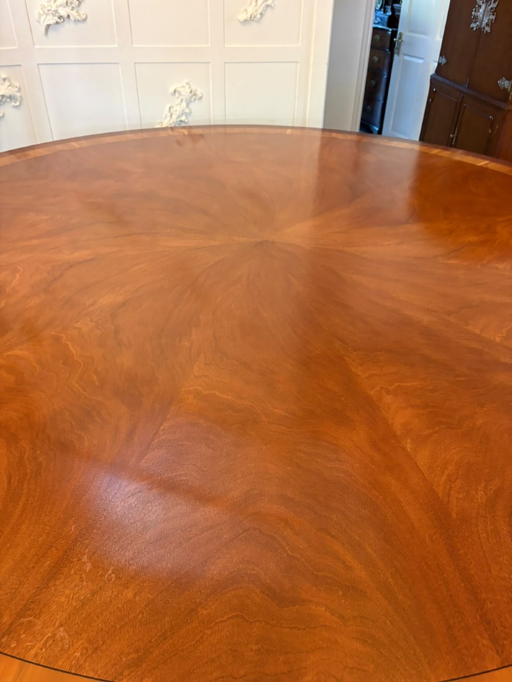 A large circular mahogany dining table featuring a yew wood crossbanded border and a central pedestal base. View XIII