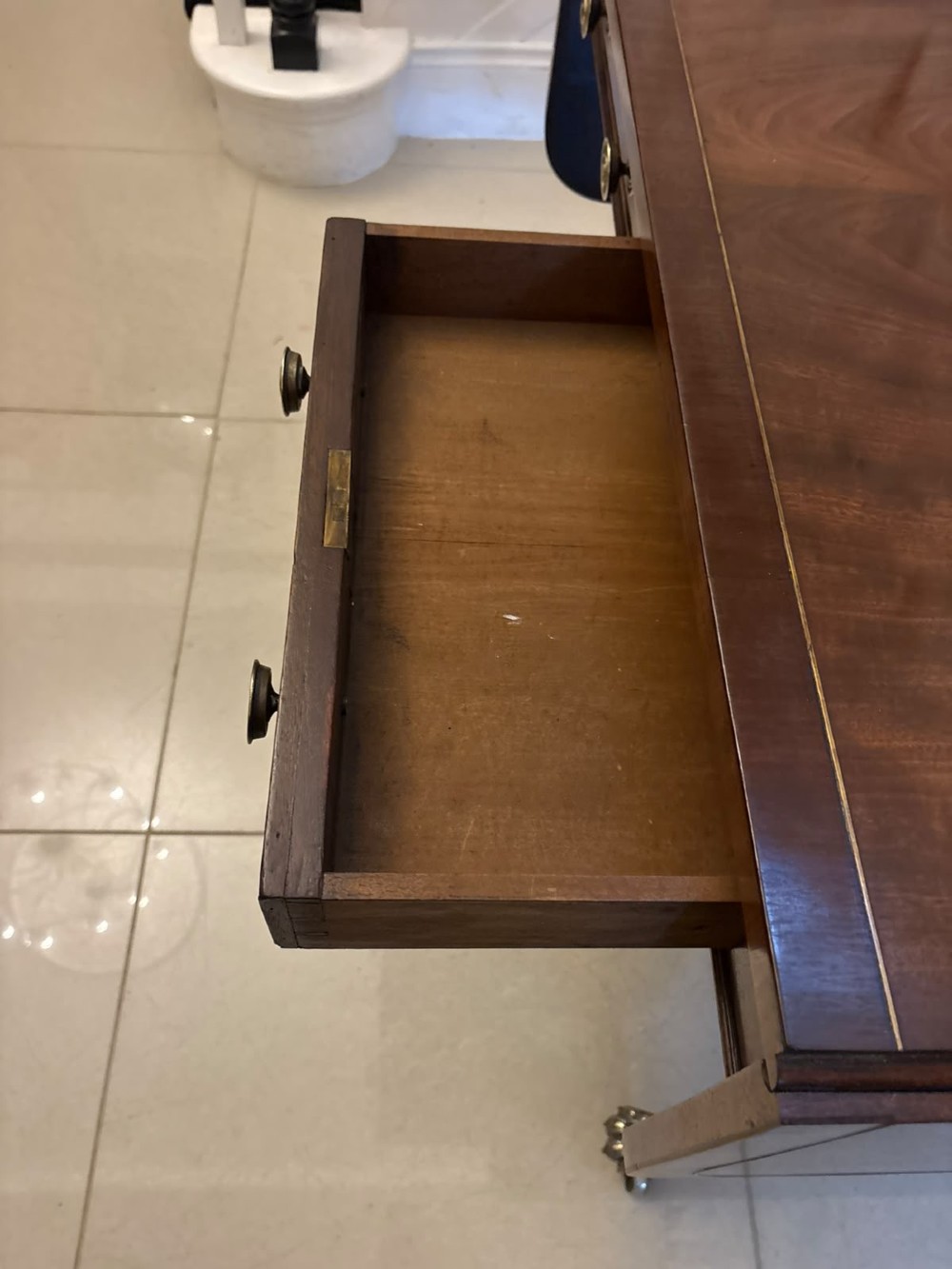 A Regency mahogany sofa table featuring two drop leaves, two front drawers with round brass knobs, reeded splayed legs, and brass paw castors. View X