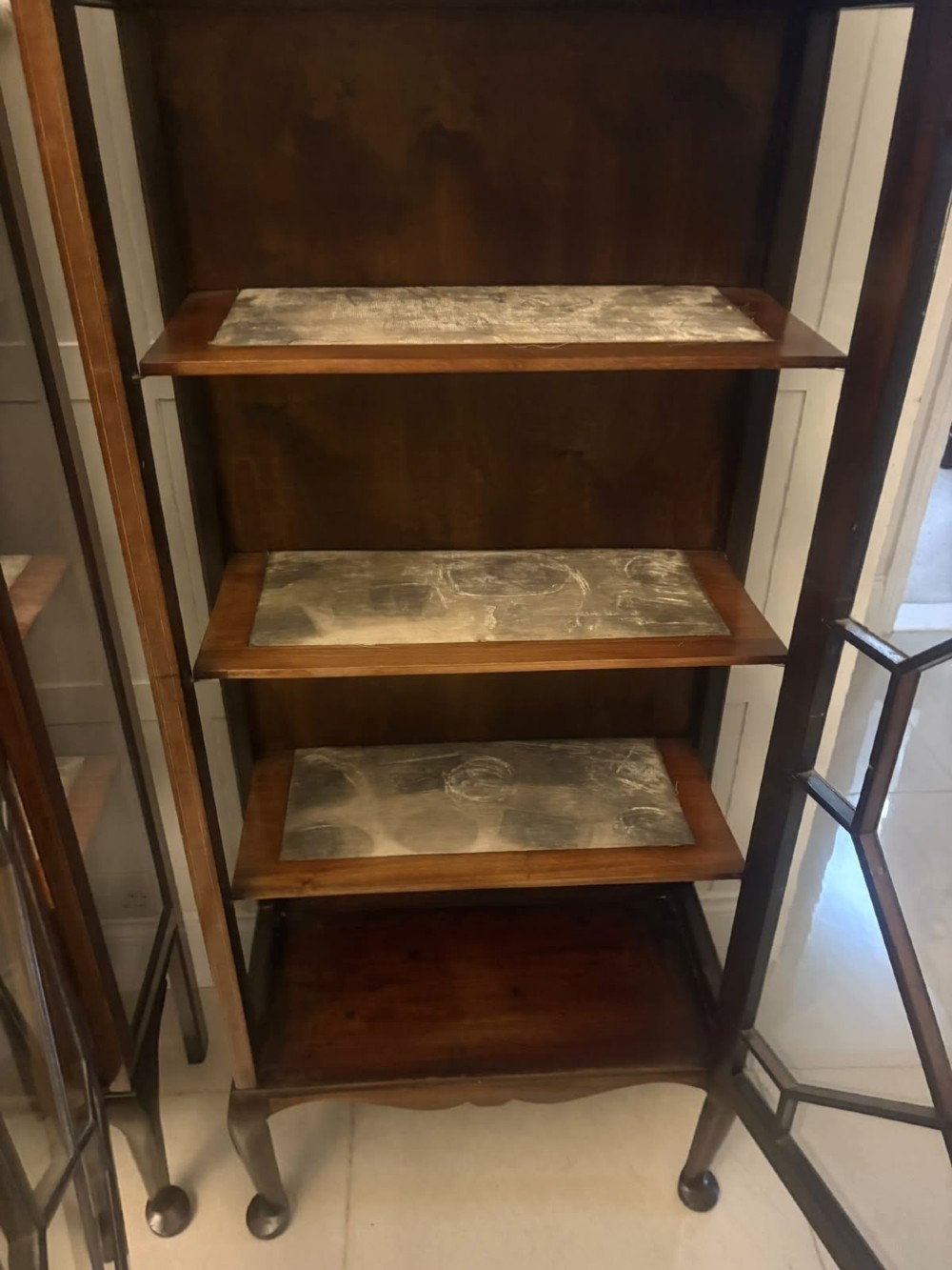 A pair of tall Edwardian mahogany display cabinets with geometric astragal glazed glass doors and slender cabriole legs. View II