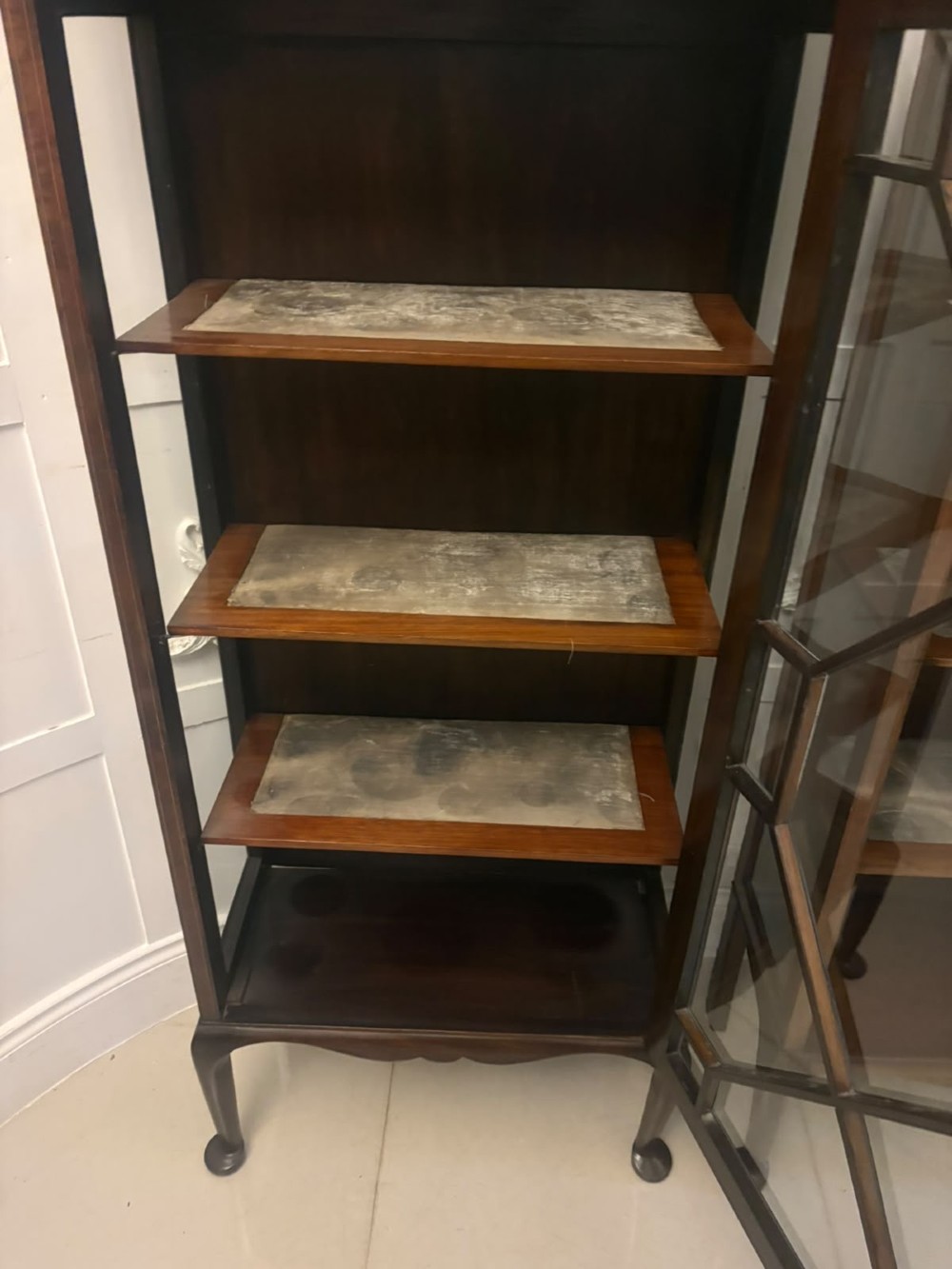 A pair of tall Edwardian mahogany display cabinets with geometric astragal glazed glass doors and slender cabriole legs. View IV