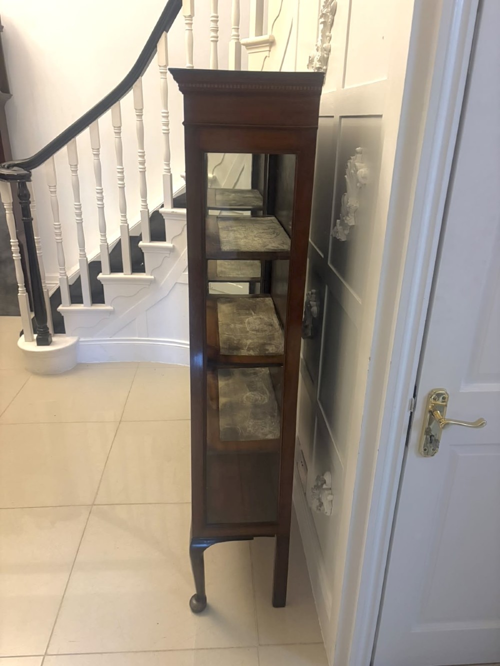 A pair of tall Edwardian mahogany display cabinets with geometric astragal glazed glass doors and slender cabriole legs. View VI