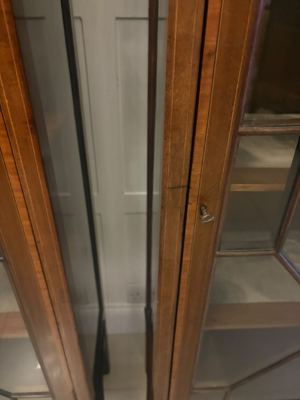 A pair of tall Edwardian mahogany display cabinets with geometric astragal glazed glass doors and slender cabriole legs. View VIII
