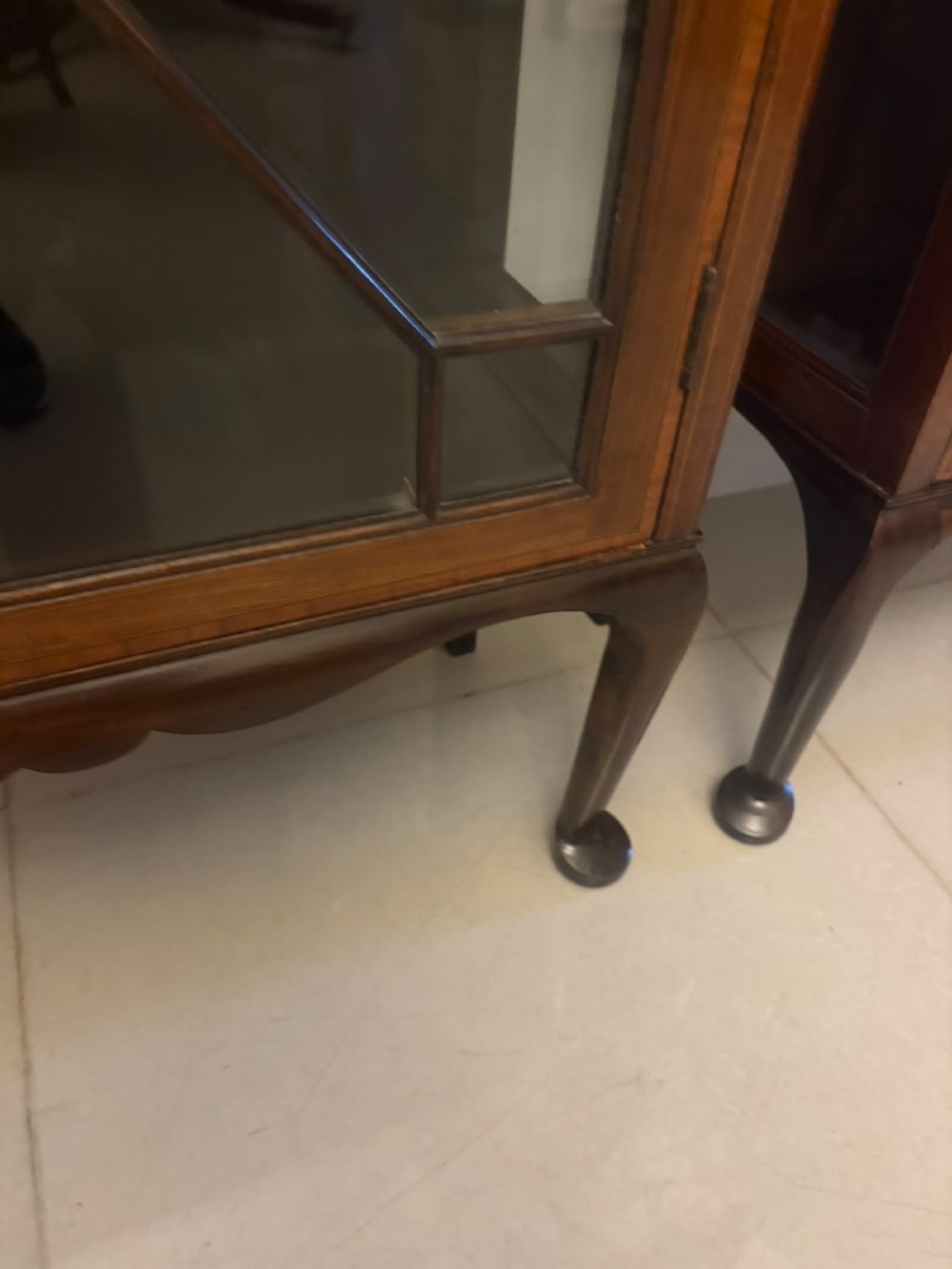 A pair of tall Edwardian mahogany display cabinets with geometric astragal glazed glass doors and slender cabriole legs. View IX