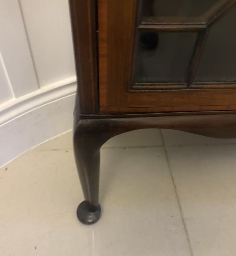 A pair of tall Edwardian mahogany display cabinets with geometric astragal glazed glass doors and slender cabriole legs. View X