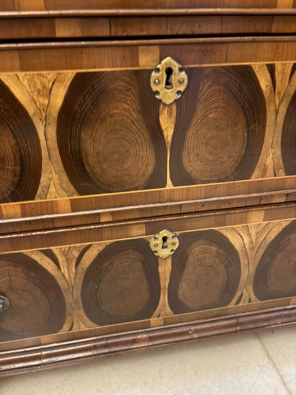 A George I yew wood and laburnum oyster veneered bachelors chest of drawers with carved corner caryatids and brass drop handles. View VIII
