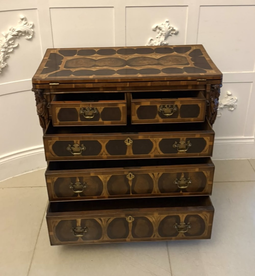 A George I yew wood and laburnum oyster veneered bachelors chest of drawers with carved corner caryatids and brass drop handles. View XI