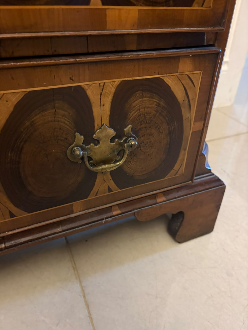 A George I yew wood and laburnum oyster veneered bachelors chest of drawers with carved corner caryatids and brass drop handles. View XII