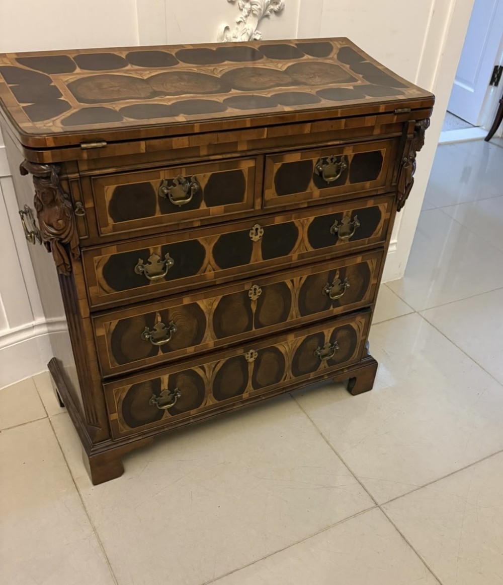 A George I yew wood and laburnum oyster veneered bachelors chest of drawers with carved corner caryatids and brass drop handles. View XIII