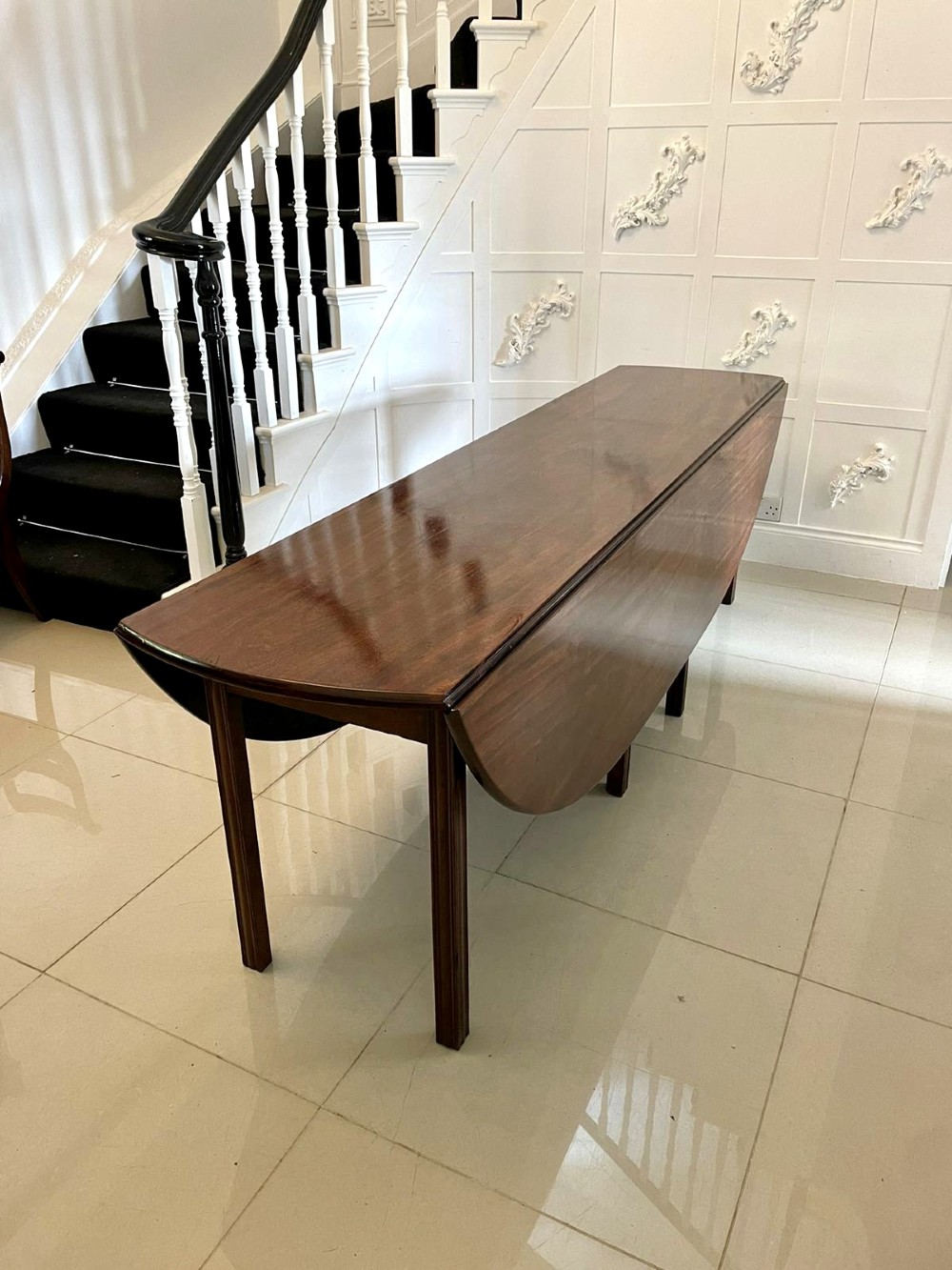 A large Georgian mahogany wake table shown with drop leaves folded down, featuring straight square legs and a polished polished timber top. View X