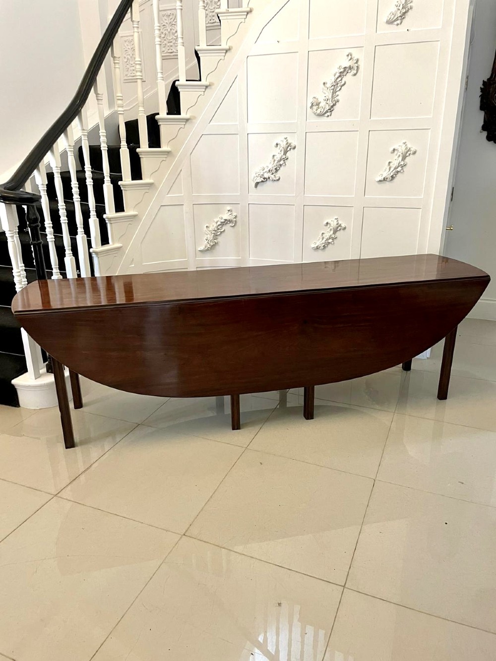 A large Georgian mahogany wake table shown with drop leaves folded down, featuring straight square legs and a polished polished timber top. View XV