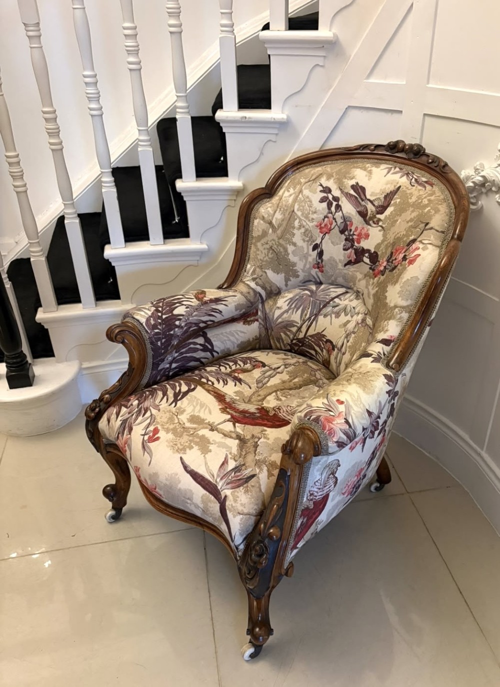 An antique Victorian carved rosewood armchair featuring floral and bird pattern upholstery with cabriole legs on castors. View XIII