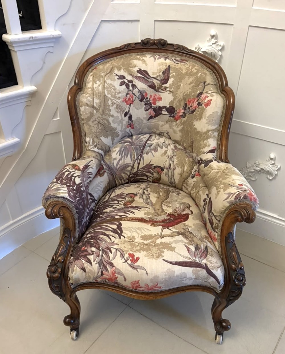 An antique Victorian carved rosewood armchair featuring floral and bird pattern upholstery with cabriole legs on castors. View XIV