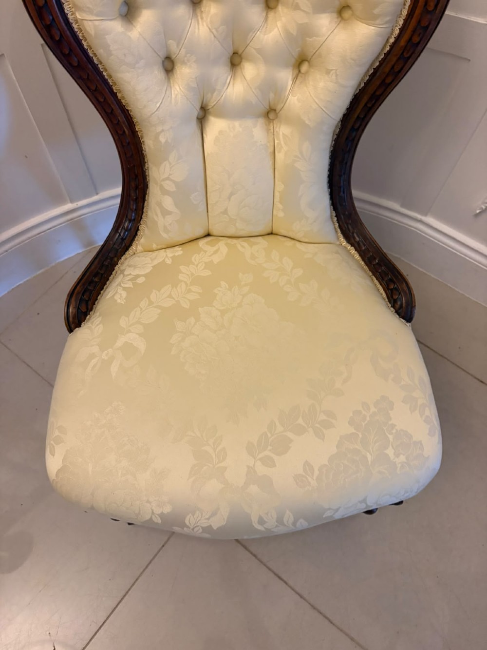 A Victorian carved walnut slipper chair featuring a button-tufted cream damask spoon-shaped backrest and cabriole front legs. View III