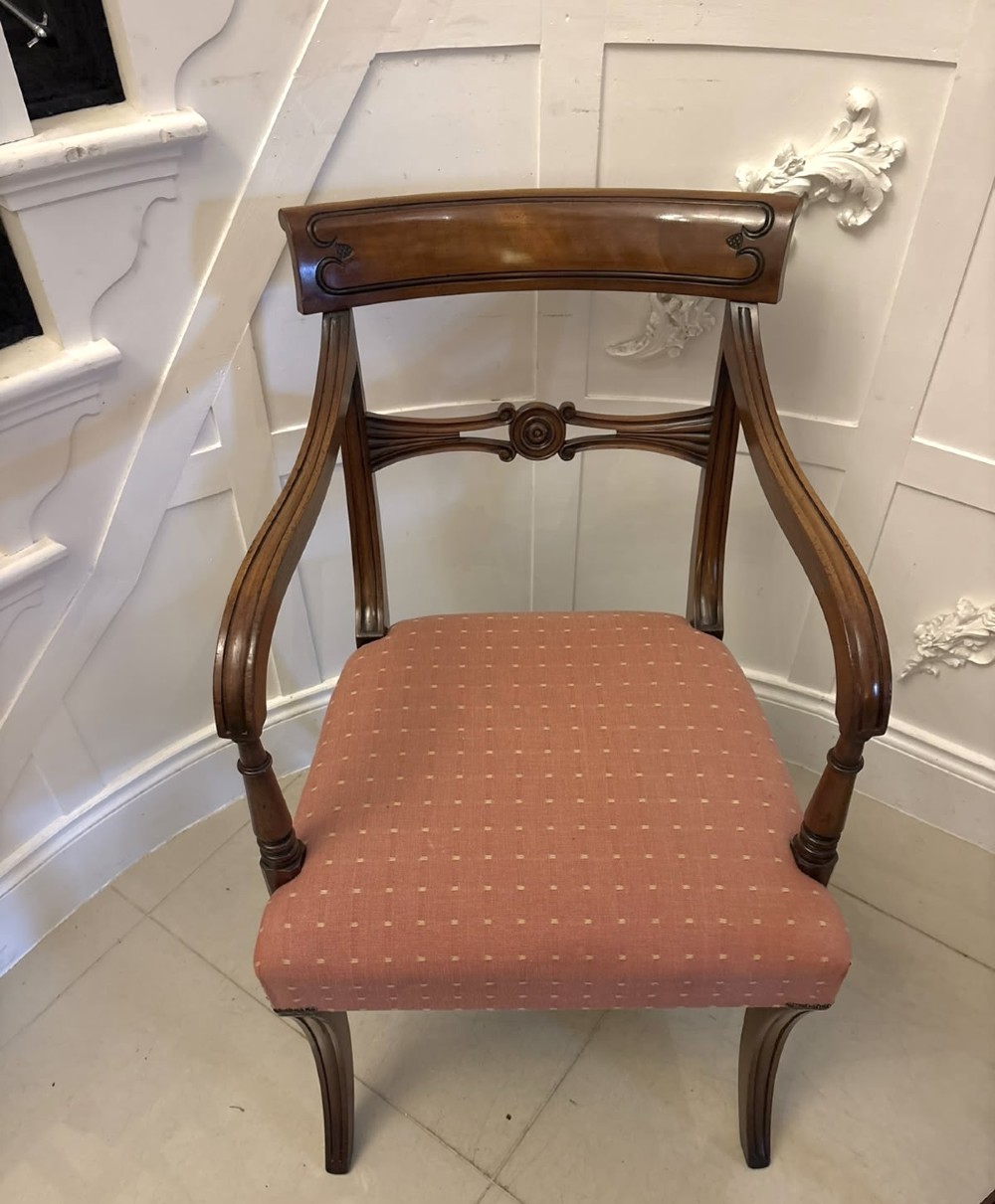 An antique mahogany carver dining chair with sweeping armrests, a carved central roundel crest bar, and a pink patterned upholstered seat. View II