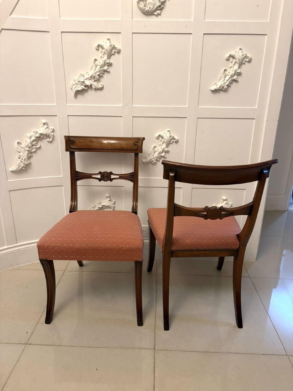 An antique mahogany carver dining chair with sweeping armrests, a carved central roundel crest bar, and a pink patterned upholstered seat. View XII