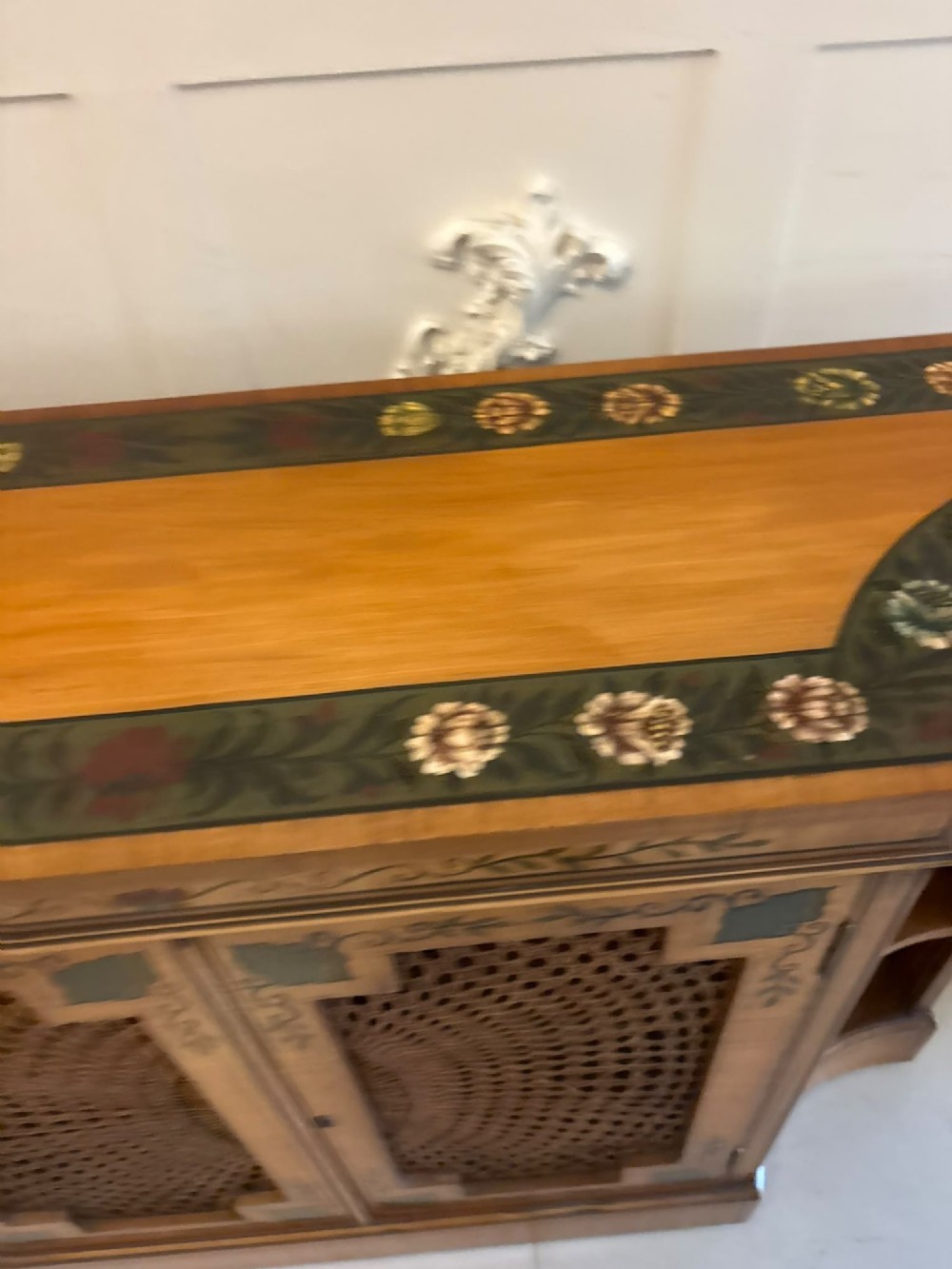 A Sheraton Revival satinwood side cabinet featuring painted leaf borders, central doors with fan-shaped woven cane panels, and open curved side shelves. View VIII