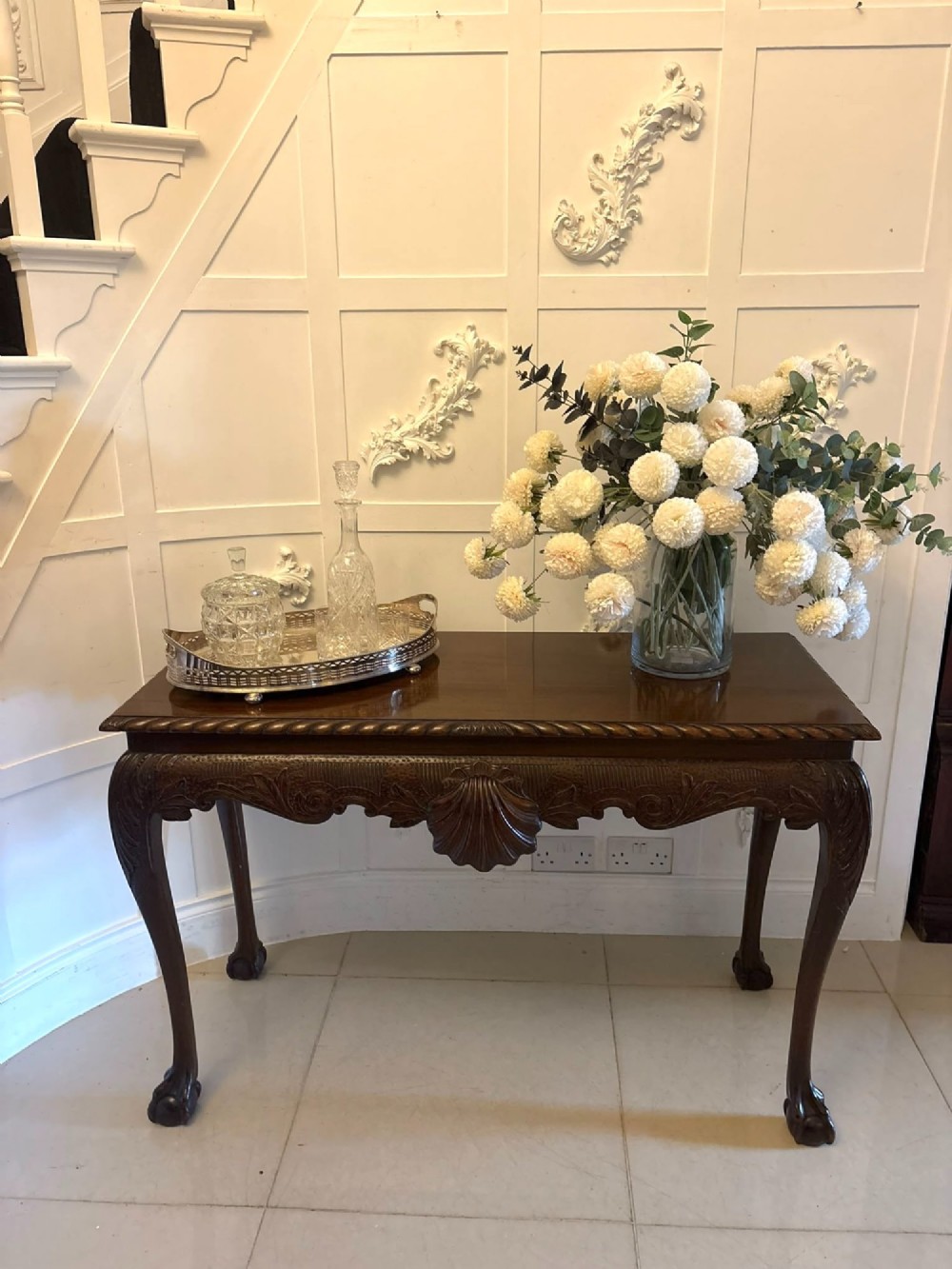 A Victorian carved mahogany console table featuring cabriole legs with ball and claw feet, a shell-carved central apron, and a gadrooned top border. View IV