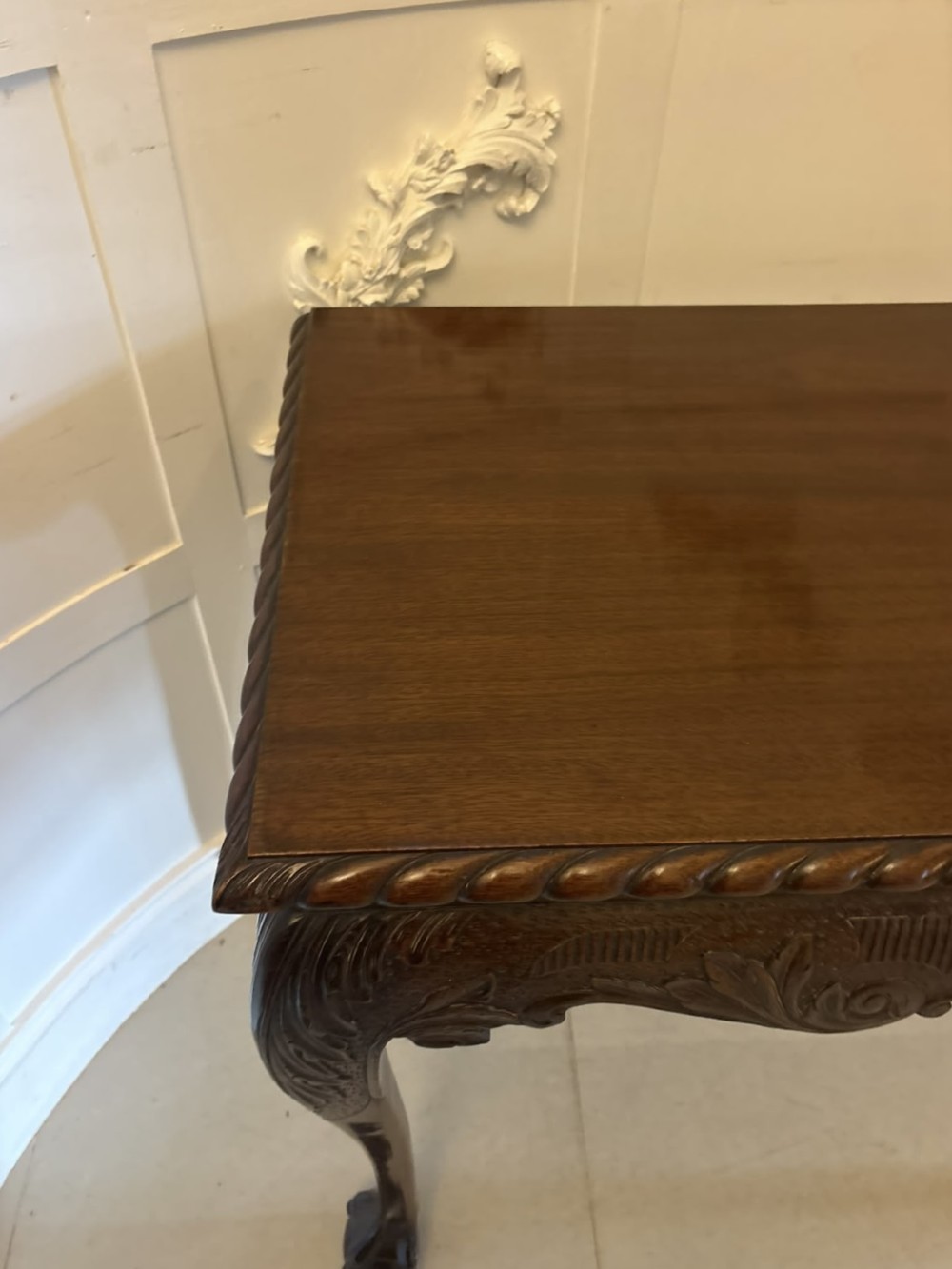 A Victorian carved mahogany console table featuring cabriole legs with ball and claw feet, a shell-carved central apron, and a gadrooned top border. View VI