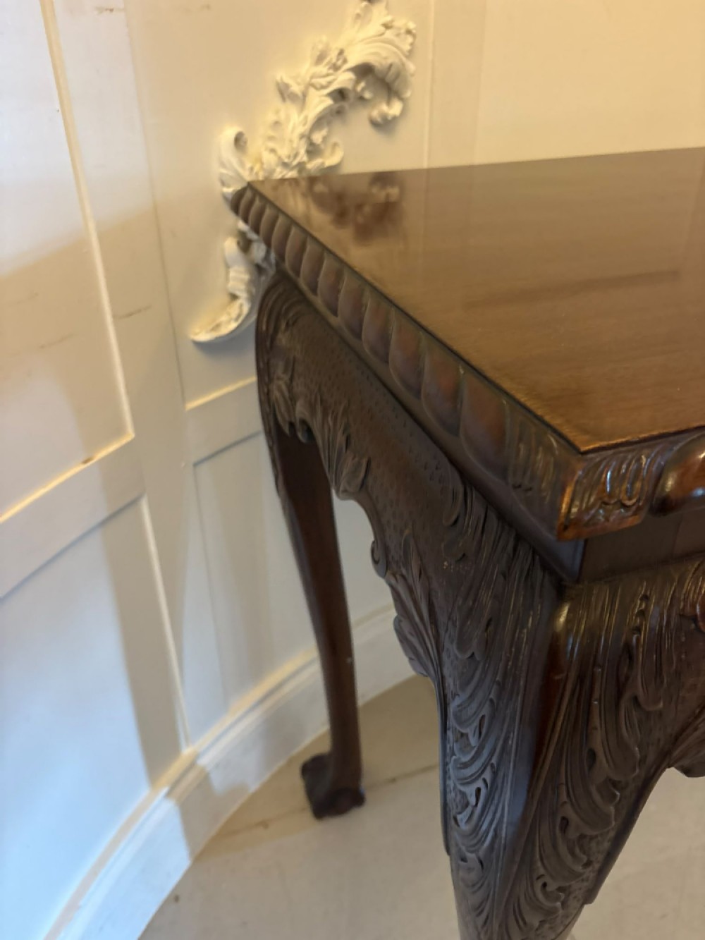A Victorian carved mahogany console table featuring cabriole legs with ball and claw feet, a shell-carved central apron, and a gadrooned top border. View IX