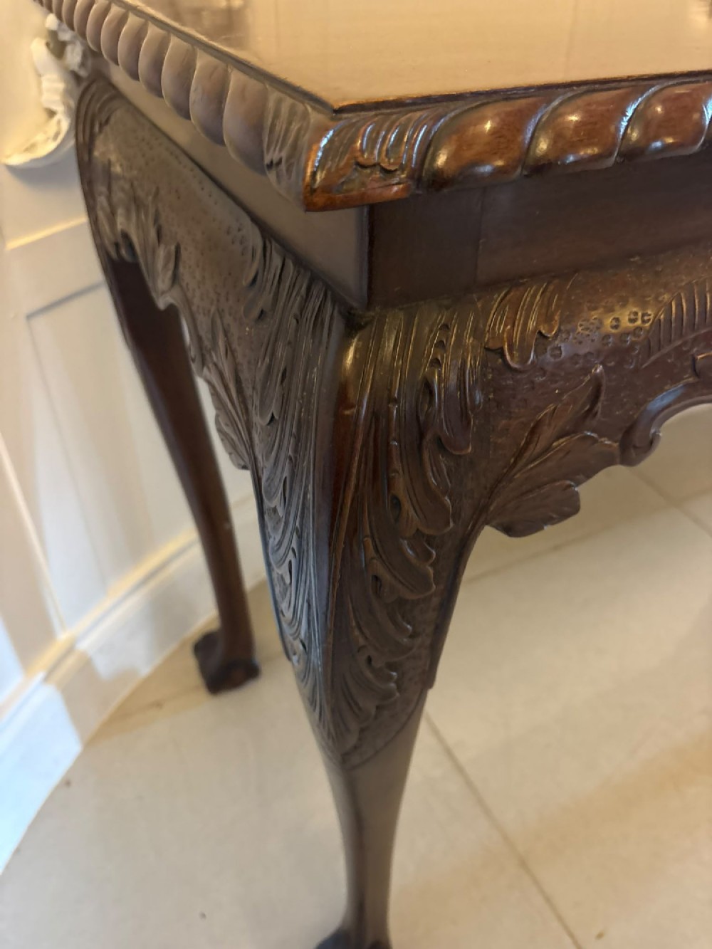 A Victorian carved mahogany console table featuring cabriole legs with ball and claw feet, a shell-carved central apron, and a gadrooned top border. View XIII