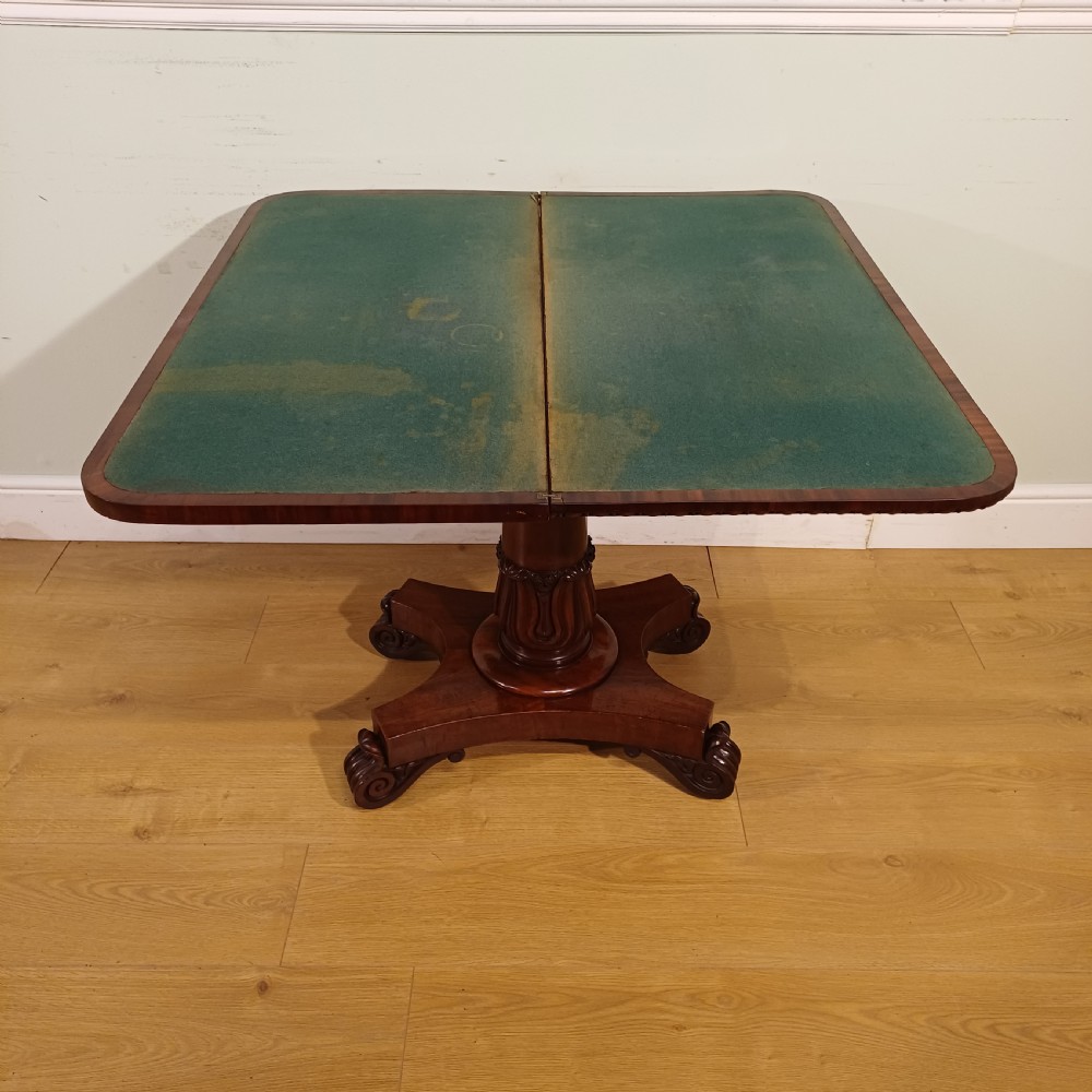 A nineteenth-century mahogany fold-over card table featuring a rectangular top with rounded corners, bead moulding along the frieze, a turned pedestal column, and a quadripartite base with carved scroll feet. View IX