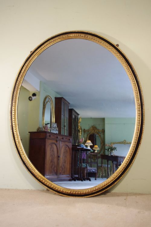 large oval ebonised and parcelgilt overmantlewall mirror - CATEGORY: ANTIQUE MIRRORS - DATED 1880