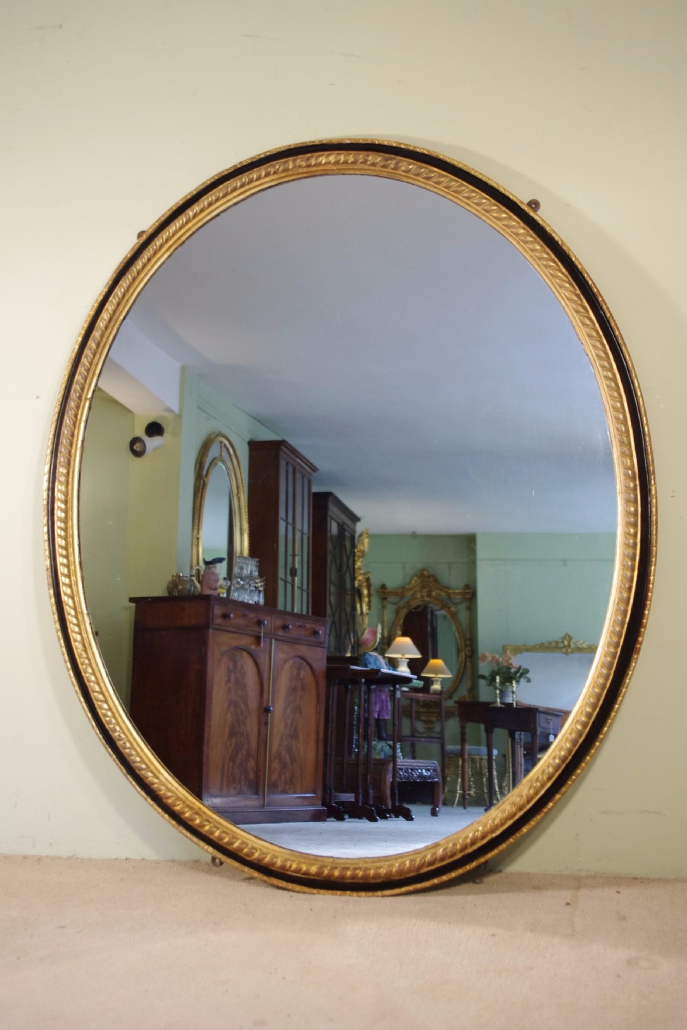 Large Oval Ebonised and Parcel-Gilt Overmantle/Wall Mirror
