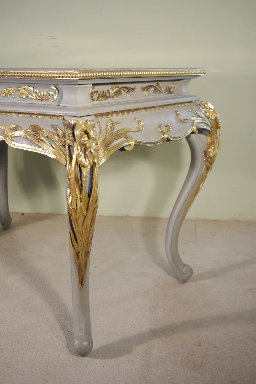 A grey painted rectangular centre table featuring ornate parcel-gilt leaf carvings on cabriole legs and an inset grey marble top. View IV