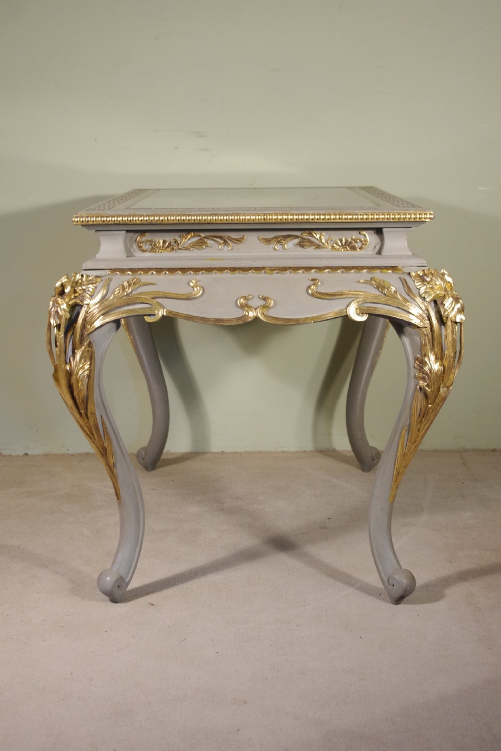 A grey painted rectangular centre table featuring ornate parcel-gilt leaf carvings on cabriole legs and an inset grey marble top. View VII