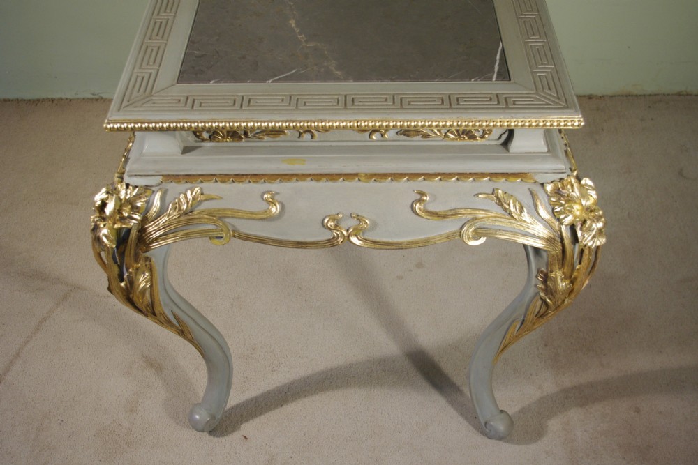 A grey painted rectangular centre table featuring ornate parcel-gilt leaf carvings on cabriole legs and an inset grey marble top. View IX
