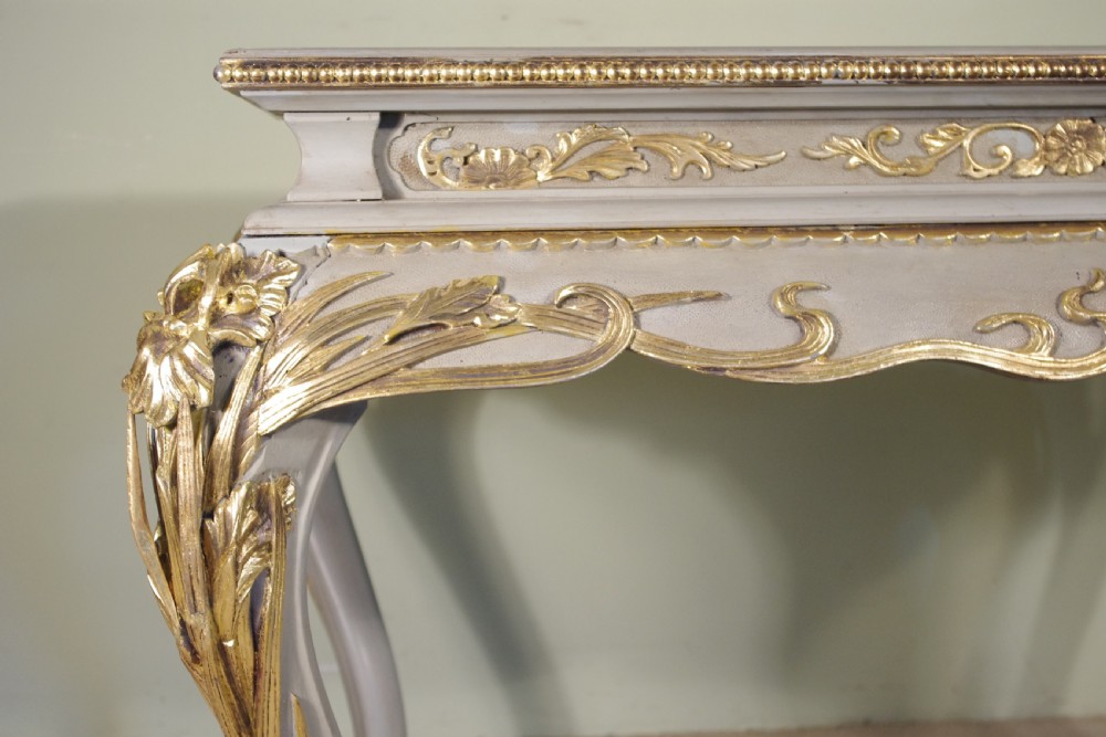 A grey painted rectangular centre table featuring ornate parcel-gilt leaf carvings on cabriole legs and an inset grey marble top. View XII