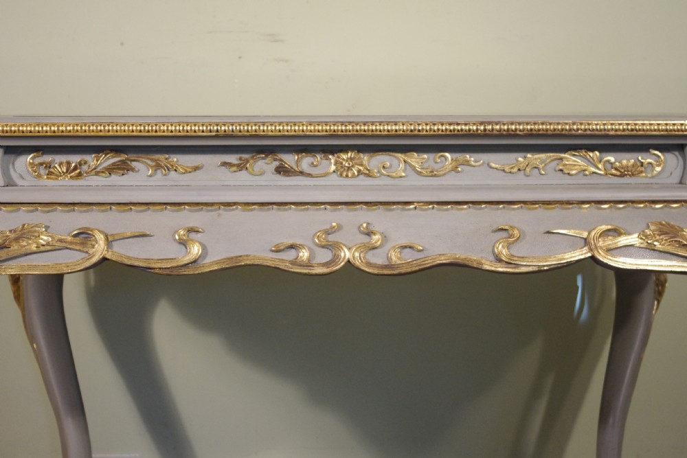 A grey painted rectangular centre table featuring ornate parcel-gilt leaf carvings on cabriole legs and an inset grey marble top. View XIV