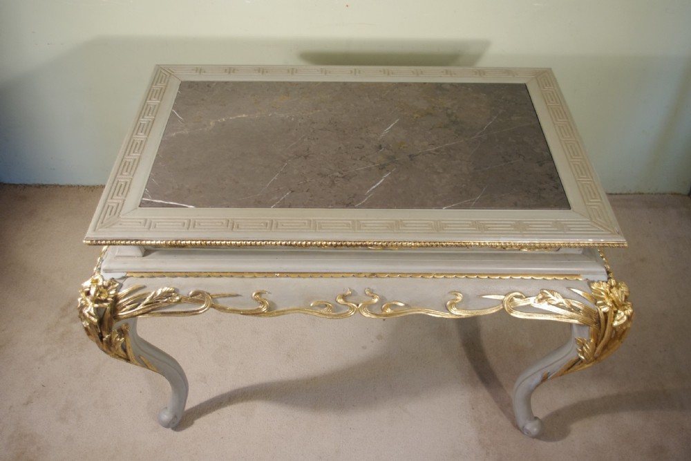 A grey painted rectangular centre table featuring ornate parcel-gilt leaf carvings on cabriole legs and an inset grey marble top. View XV